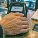 Code carte bancaire oublié : main cache le clavier du terminal de paiement
